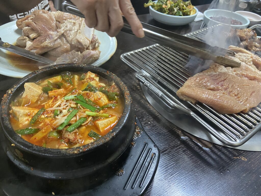 無料で提供されるテンジャンチゲ（韓国味噌チゲ）と、網の上で焼かれているデジカルビ。