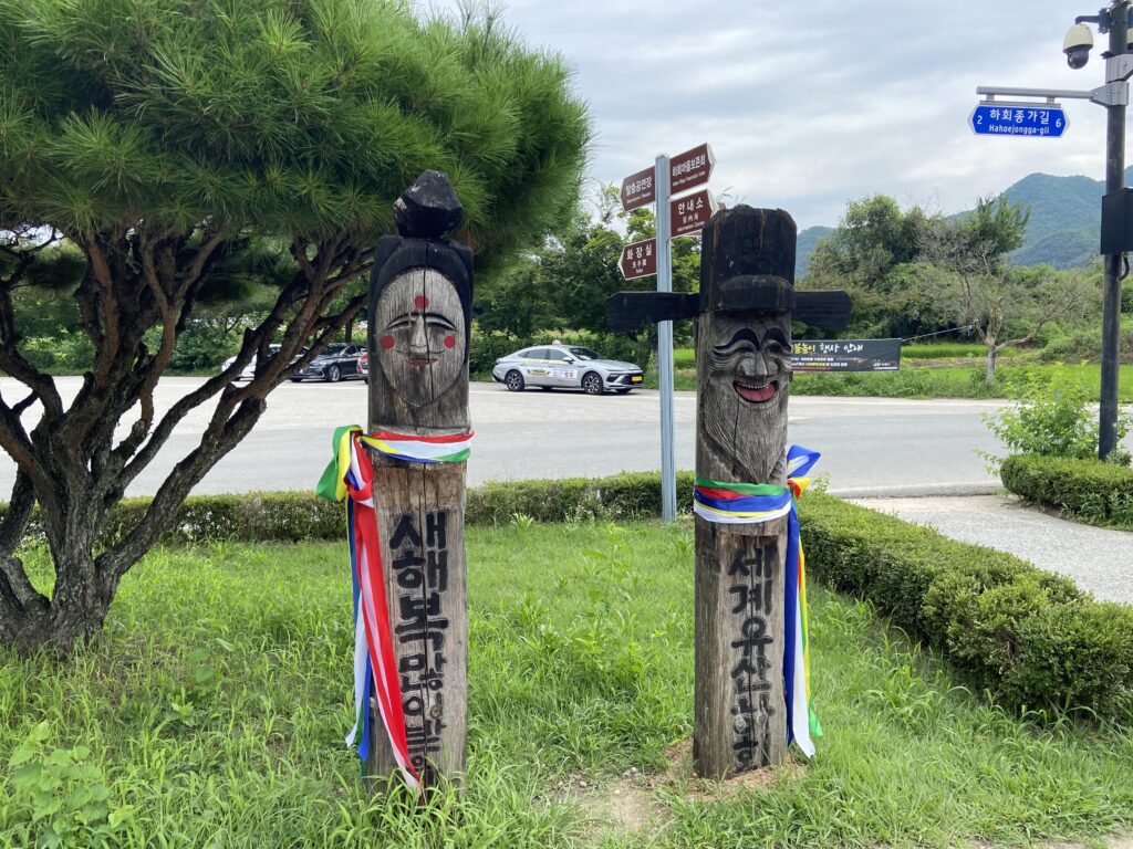 韓国の河回村の入口付近にある、木製の道しるべ「チャンスン」。リボンのような飾りを付けた2本の柱が写っている。