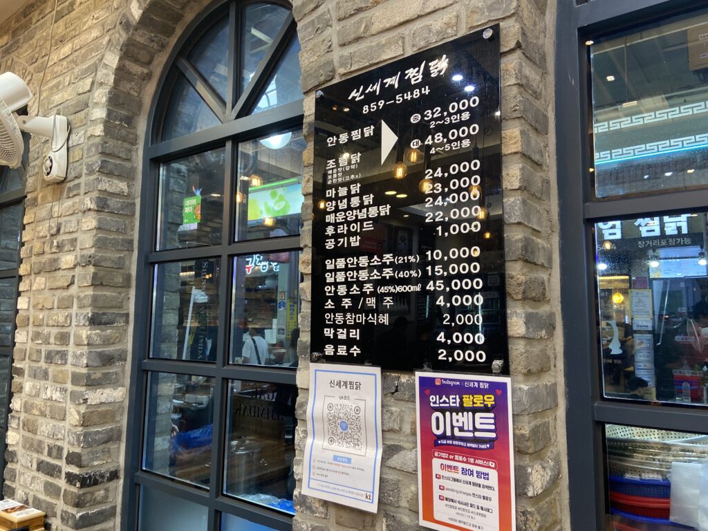 신세계찜닭 매장 외벽에 게시된 안동찜닭 등 요리 이름과 가격이 적힌 검은색 메뉴판.