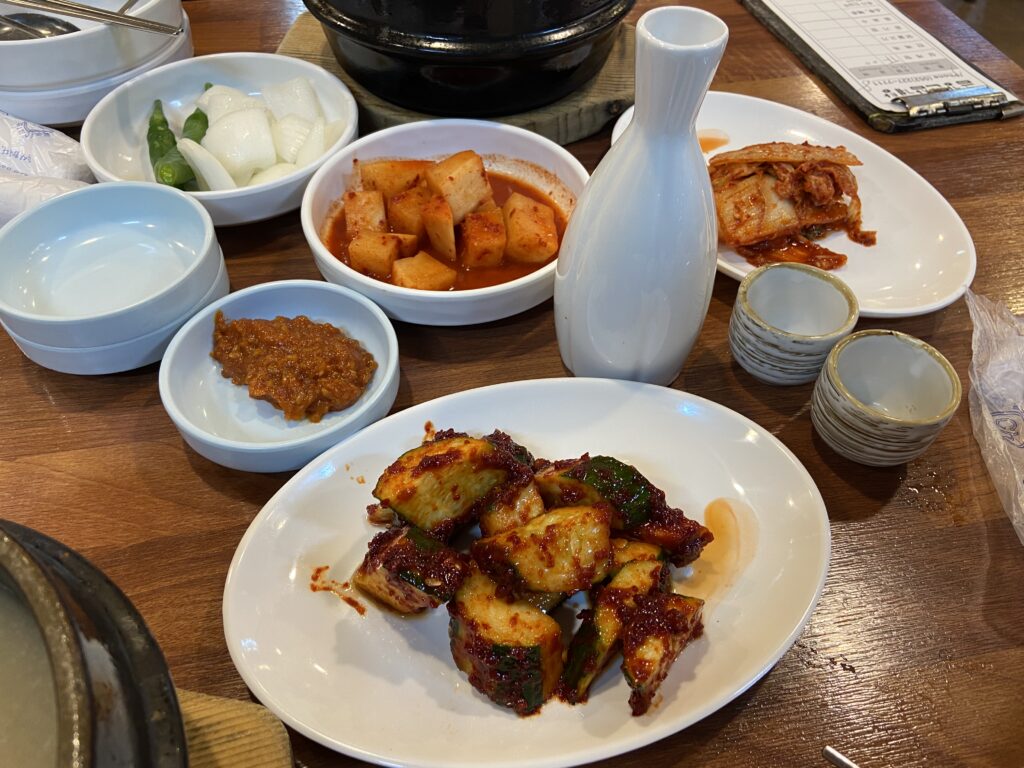 오이무침, 깍두기, 김치 그리고 인삼주가 차려진 기본 상차림.