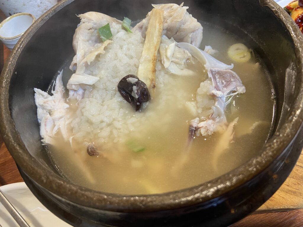 Samgyetang chicken broken apart to reveal glutinous rice, ginseng, and jujube inside.